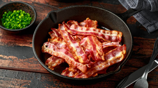 istock Fried crunchy Streaky Bacon pieces in a cast iron skillet 1257722930