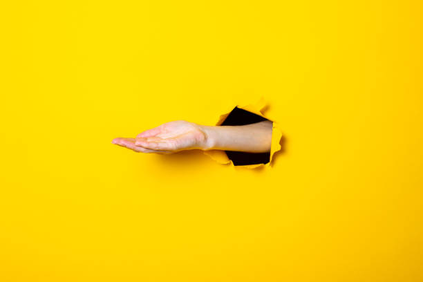 istock Opened male hand, palm up on a yellow background. Sign language 1257723008