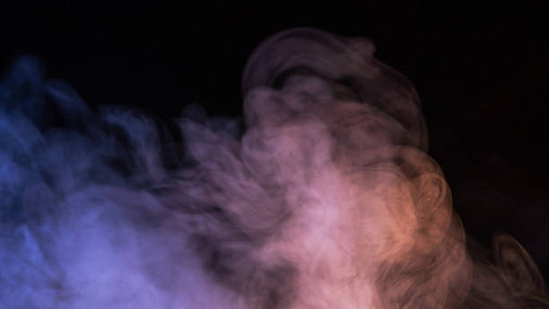 istock Conceptual image of multi-colored smoke isolated on dark black background and wooden table. 1257724442