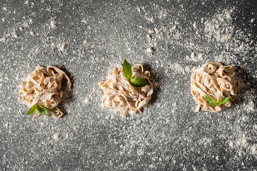 Fresh organic vegan pasta made at home over dark background