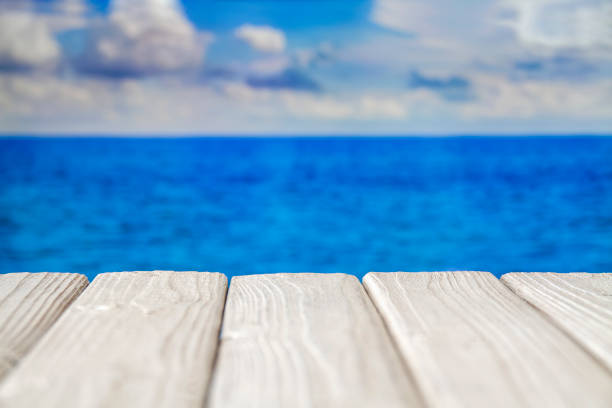 istock White empty wooden walkway at seacoast with cloudy sky 1257724739