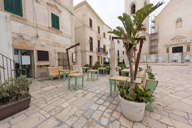 Matera, Italy - September 14, 2019: Evening view of the city of Matera, Italy, with the colorful lights highlighting patios of sidewalk cafes in the Sassi di Matera a historic district in the city of Matera. Basilicata. Italy