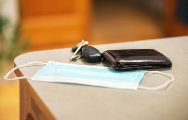 Ready to go out - post Covid-19 lockdown A facemask, wallet and set of keys on a domestic table, ready for heading out. car keys table stock pictures, royalty-free photos & images