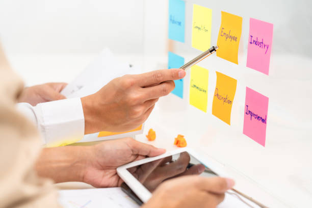 istock Creative group of business people brainstorming use sticky notes to share idea on glass window or table in office 1257728193