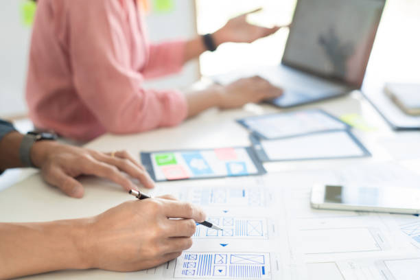 istock Graphic designers team work together with UX UI designer planning application template layout mobile phone prototype, User experience concept. 1257729462