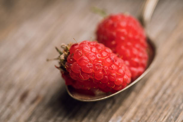 Freshly harvested raspberry on the rustic wooden background. Selective focus. Shallow depth of field.
