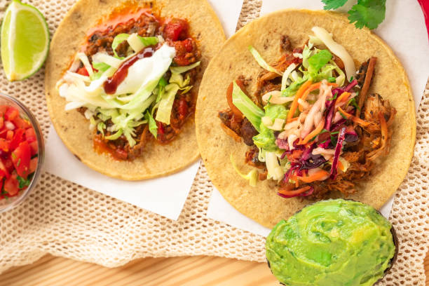 istock Mexican traditional authentic homemade tacos with pulled pork beef chili con carne serve with tomato salad and avocado guacamole and dip sauce 1257734591