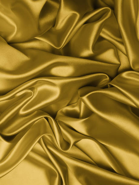 istock Beautiful smooth elegant wavy golden yellow satin silk. 1257738016
