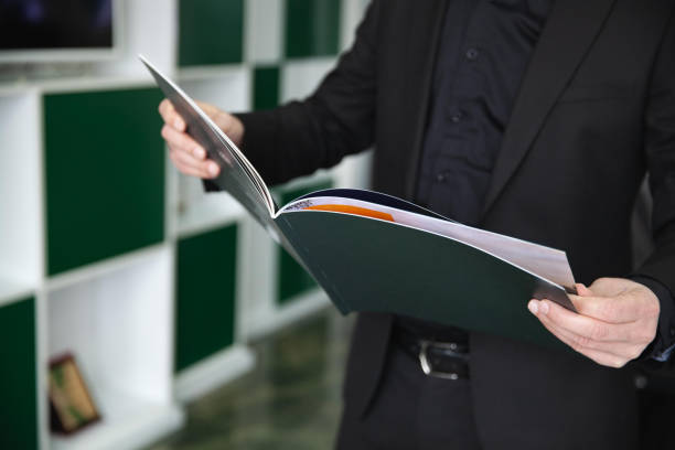 istock Businessman in black suit reading print presentation. 1257743748