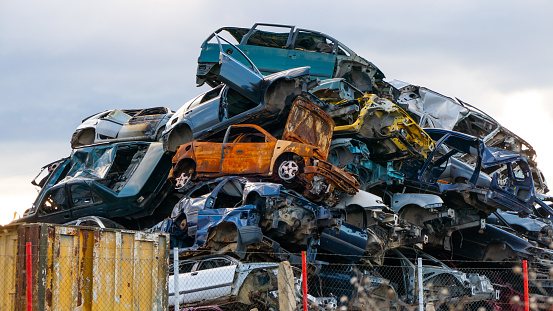 Heap of scrap cars. Crushed cars stacked up for recycling. Old damaged cars on the junkyard waiting for recycling