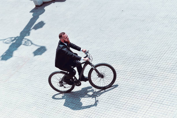istock Businessman Enjoying Work Break To Ride Bicycle On Town Square 1257748622