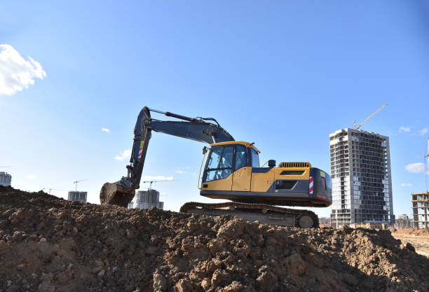 istock Excavator working at construction site on earthworks. Backhoe on road work digs ground. Paving out sewer line. 1257748646