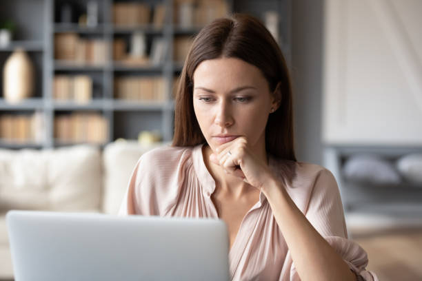 istock Thoughtful woman looking at laptop screen, pondering project 1257750258