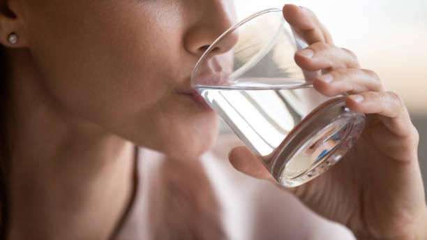 nahaufnahme frau trinken reines mineralwasser, halten glas - women close up beautiful beauty in nature stock-fotos und bilder