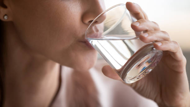 bliska kobieta pije czystą wodę mineralną, trzymając szkło - beautiful holding young adult glass zdjęcia i obrazy z banku zdjęć