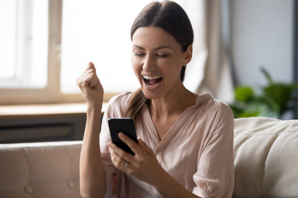 istock Excited woman looking at phone screen and celebrating win 1257750306