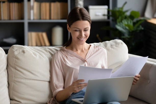 istock Smiling woman reading good news in papers, checking documents 1257750313
