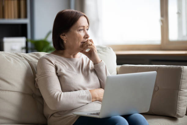istock Mature woman using laptop, thinking about finance or health problem 1257750319