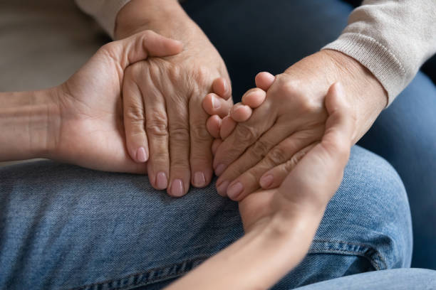 istock Young woman holding older mother hands, help and support 1257750330