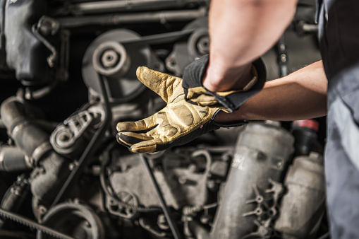 Caucasian Heavy Duty Diesel Engines Mechanic Preparing For Work Wearing Safety Gloves