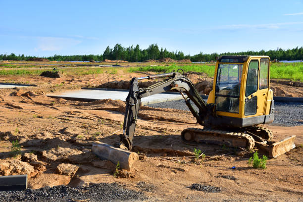 istock Mini excavator digg trench to lay cables concrete curbs and paving slabs at construction site 1257753744