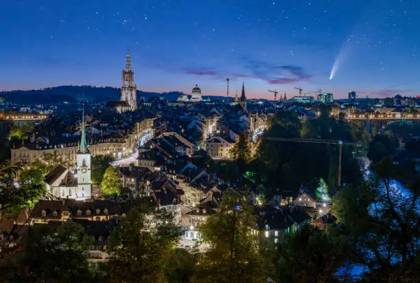 Photo of Comet C/2020 F3 Neowise in night sky over old town of Bern, Switzerland at twilight