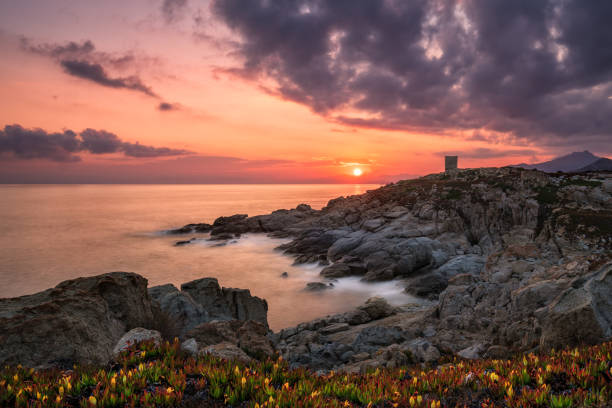 istock Sun rising behind genoese tower in Corsica 1257754922