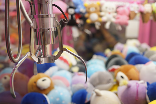 Close up of the doll claw machine of games arcade in shopping mall