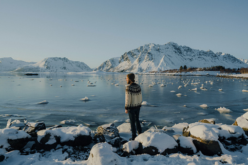Man  walking on seaside in winter on Lofoten island
