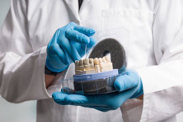 istock Dentist's / dental technician's hand in gloves are presenting a dental imprint with artificial dentition ready for use 1257758059