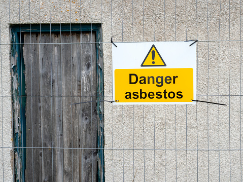 Asbestos warning sign outside a derelict building