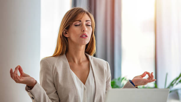 istock Young woman practicing meditation at the office desk. 1257759656