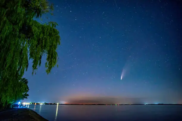 Photo of Comet C/2020 F3 Neowise in night sky over Dnieper river, Ukraine