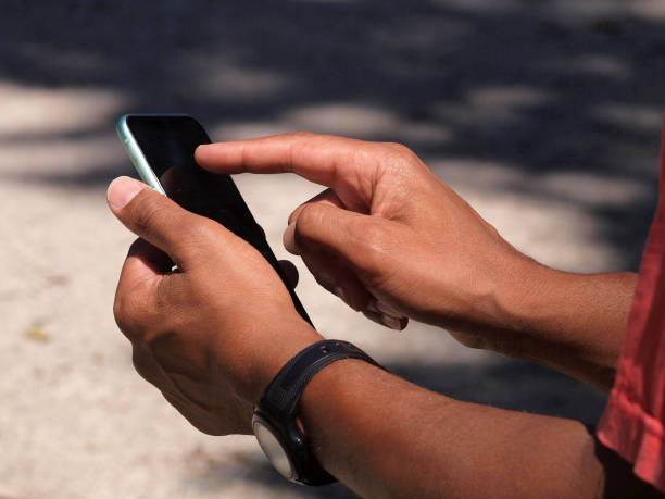 istock Hands of a mixed race man using smartphone outside 1257761665
