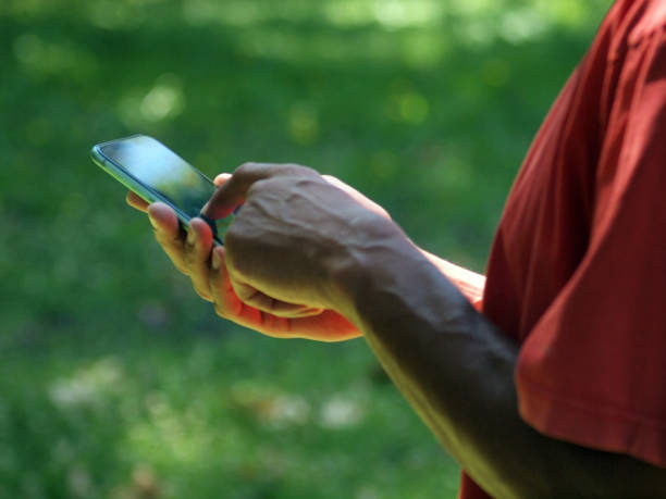 istock Hands of a mixed race man using smartphone outside 1257761674