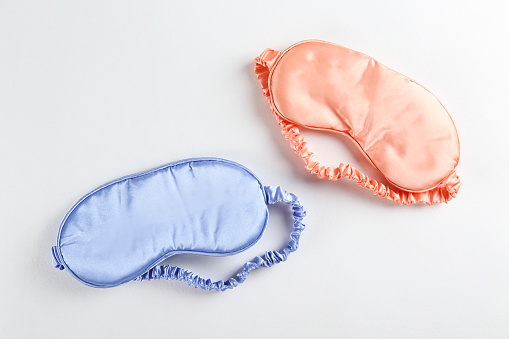Top view shot of sleeping mask isolated on bright background. Close up, copy space, flat lay.