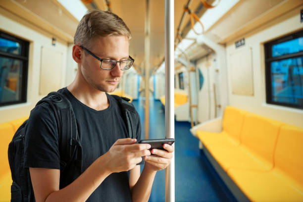 istock A man in an empty subway car is typing something on his phone 1257769776
