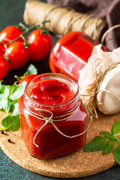 istock Tomato paste. Fresh tasty tomato sauce with ripe tomatoes and basil on a stone or slate background. 1257770989
