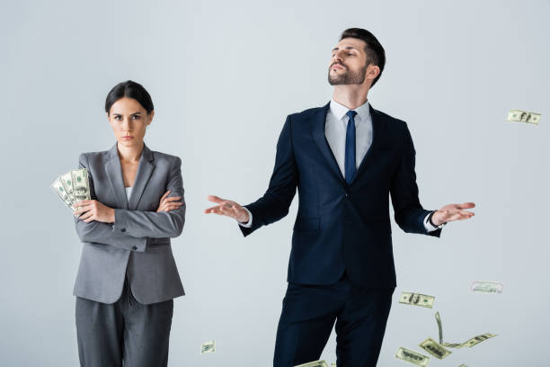 attractive businesswoman holding dollars near arrogant businessman standing on white attractive businesswoman holding dollars near arrogant businessman standing on white arrogance stock pictures, royalty-free photos & images