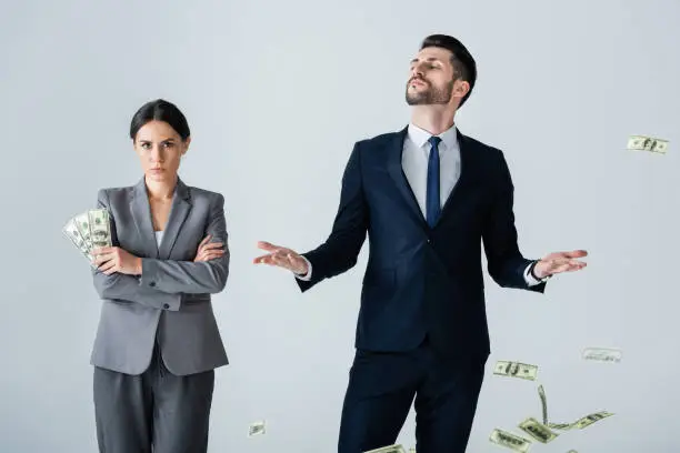 attractive businesswoman holding dollars near arrogant businessman standing on white