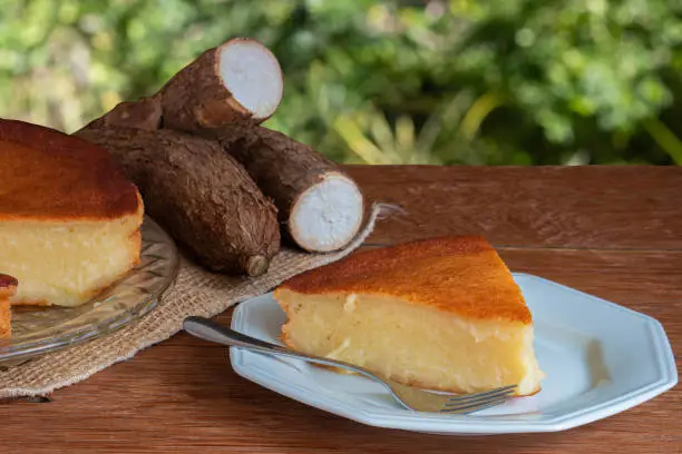 Manioc cake on wooden table with green background. Copy space.