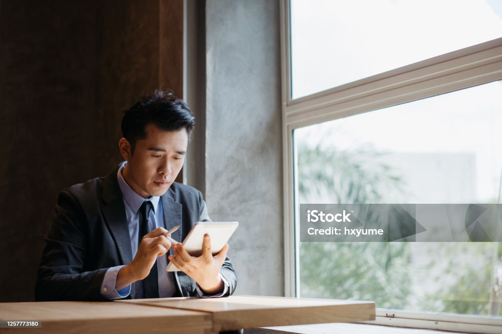 Young asian businessman working with digital tablet and stylus pen Digital Tablet Stock Photo