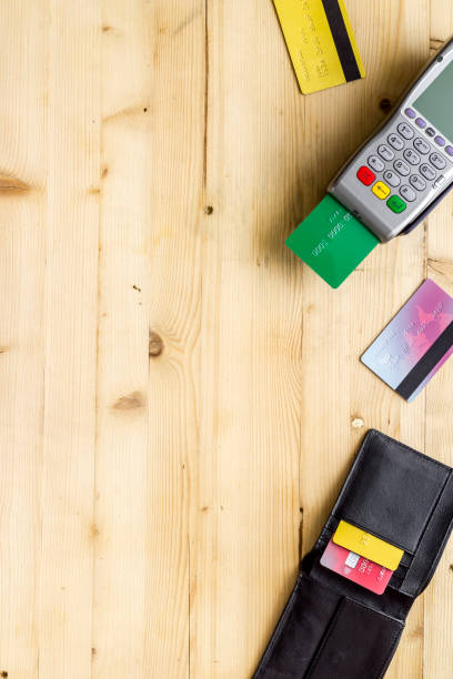 istock Payment by credit card. Terminal on wooden background top-down copy space 1257776553