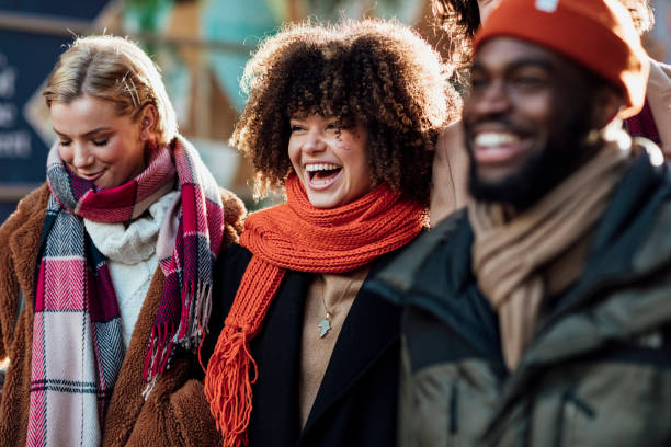 Good Friends Laughing A mixed-race woman smiles and laughs and makes good memories with close friends whilst spending the day in the city visiting the Xmas Market in Newcastle upon Tyne. winter fashion stock pictures, royalty-free photos & images