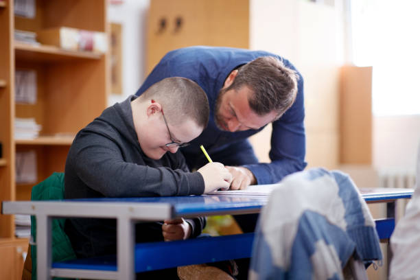 istock Teacher working with intellectual disabled boy on his drawing skills 1257778672