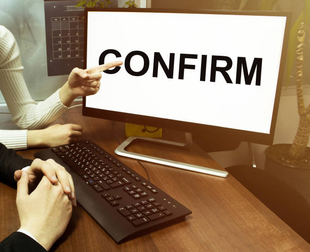 istock male and female hand, computer with text Confirm with office background 1257781314