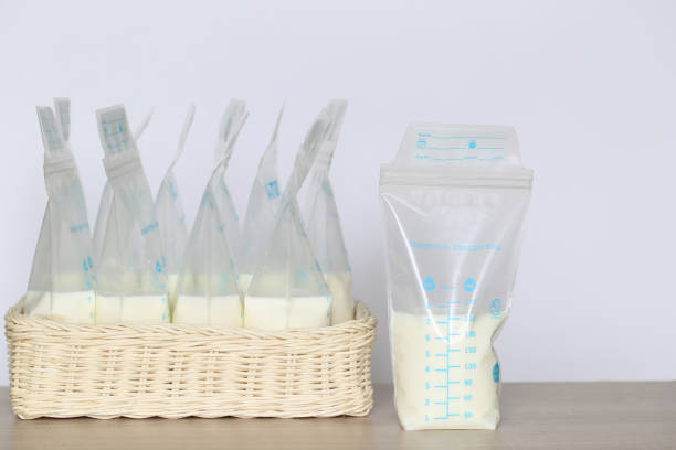zamrożone torby do przechowywania mleka dla nowego dziecka na drewnianym stole - mleko z piersi zdjęcia i obrazy z banku zdjęć