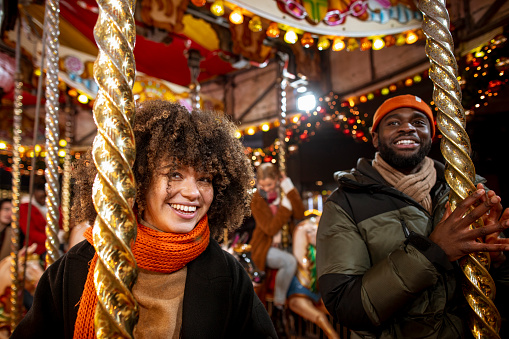 A close-up view of two friends on a merry-go-round enjoying the festive fun at the Christmas market in the North-East of England.