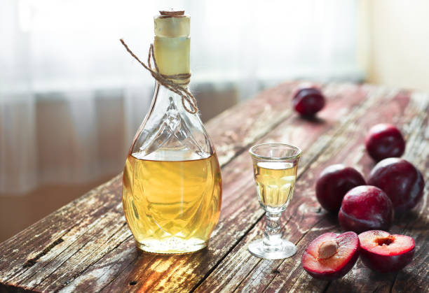 una botella de brandy de ciruela - rakija o rakia slivovica y ciruelas frescas - slivovitz fotografías e imágenes de stock