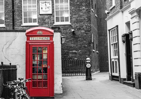 Monochrome image with red phonebox located in the centre of London